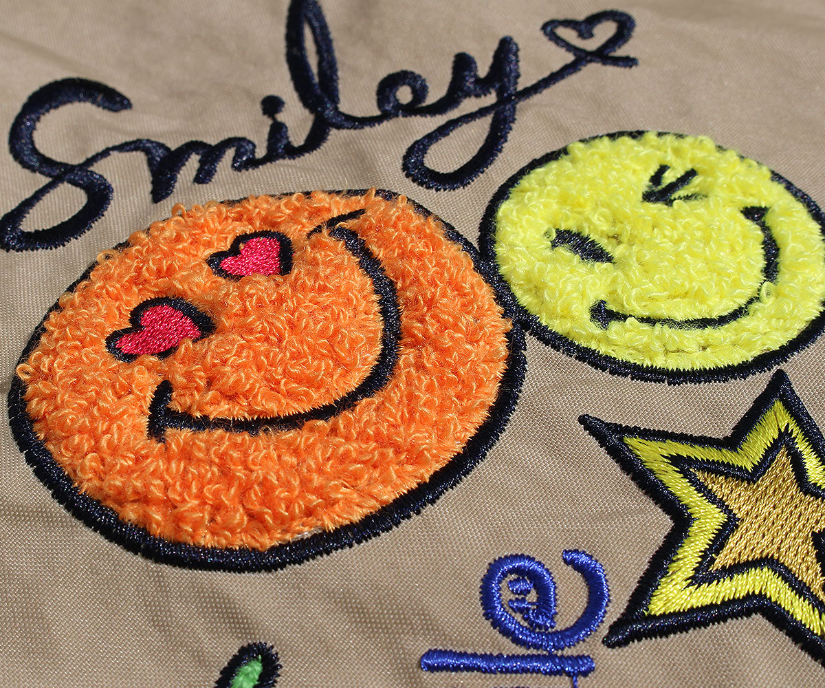 スマイルマークやスター、四つ葉のクローバーなど、カラフルな刺繍で描きました。