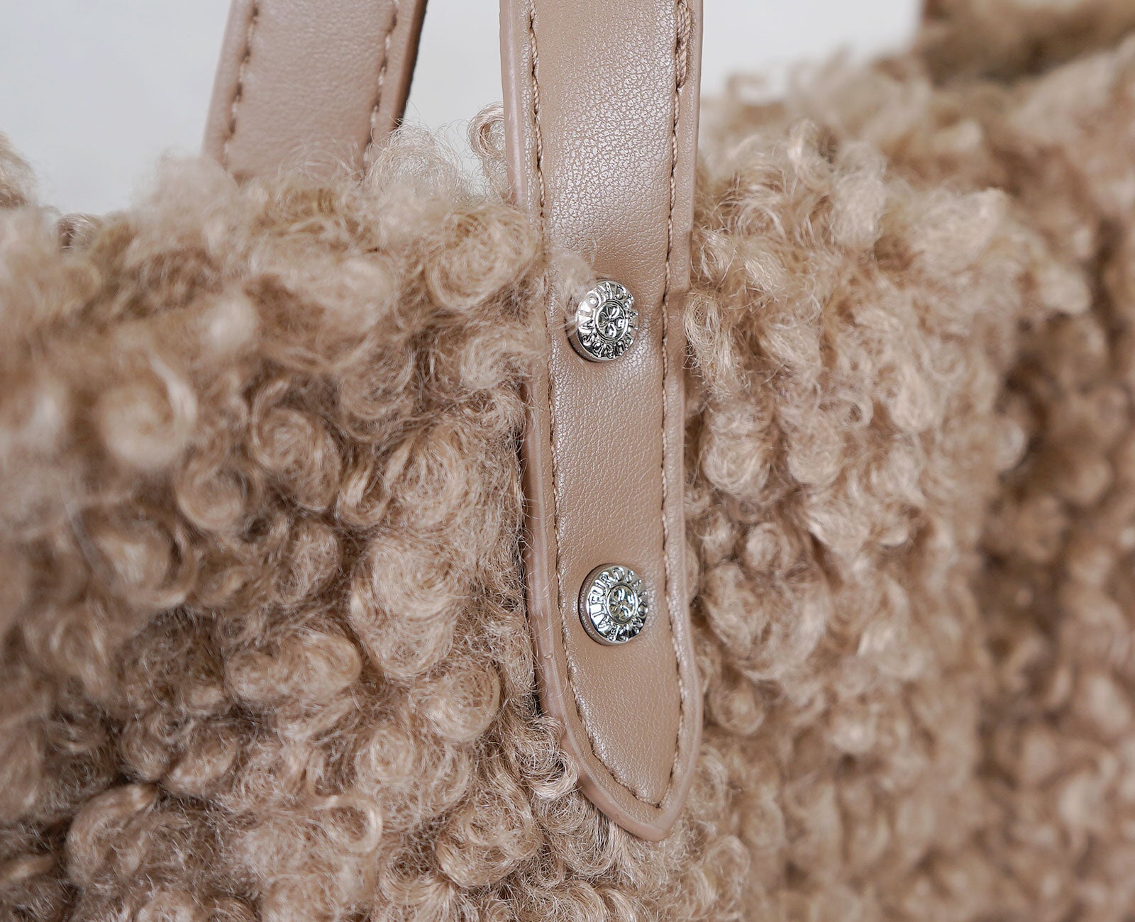 ハンドル根元のスナップボタンには、四葉のクローバーをあしらい、さりげない遊び心と華やかさをプラス