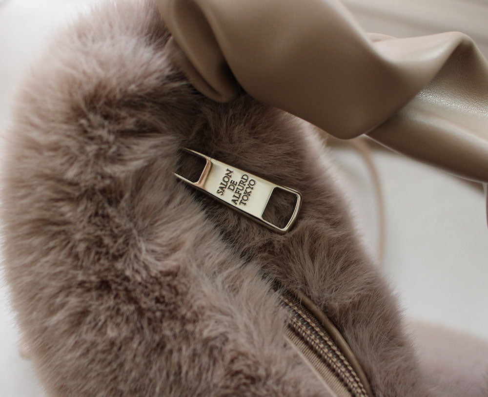 メインファスナーはシルバーに煌めくブランドロゴ入りチャームを採用。