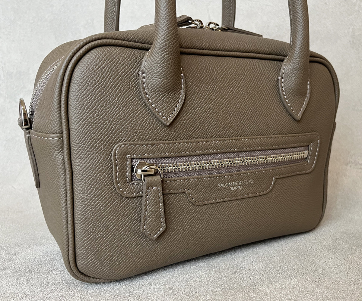 バッグの裏面には、実用性と美しさを兼ね備えたファスナー付きポケットを配置