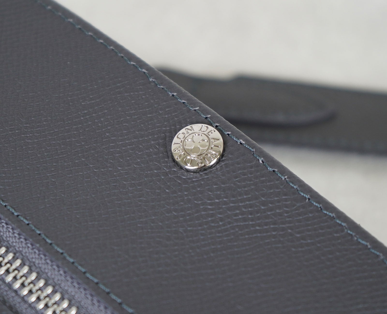 上質な遊び心をひとさじ。 幸せを呼ぶ四つ葉モチーフのスナップボタン付き