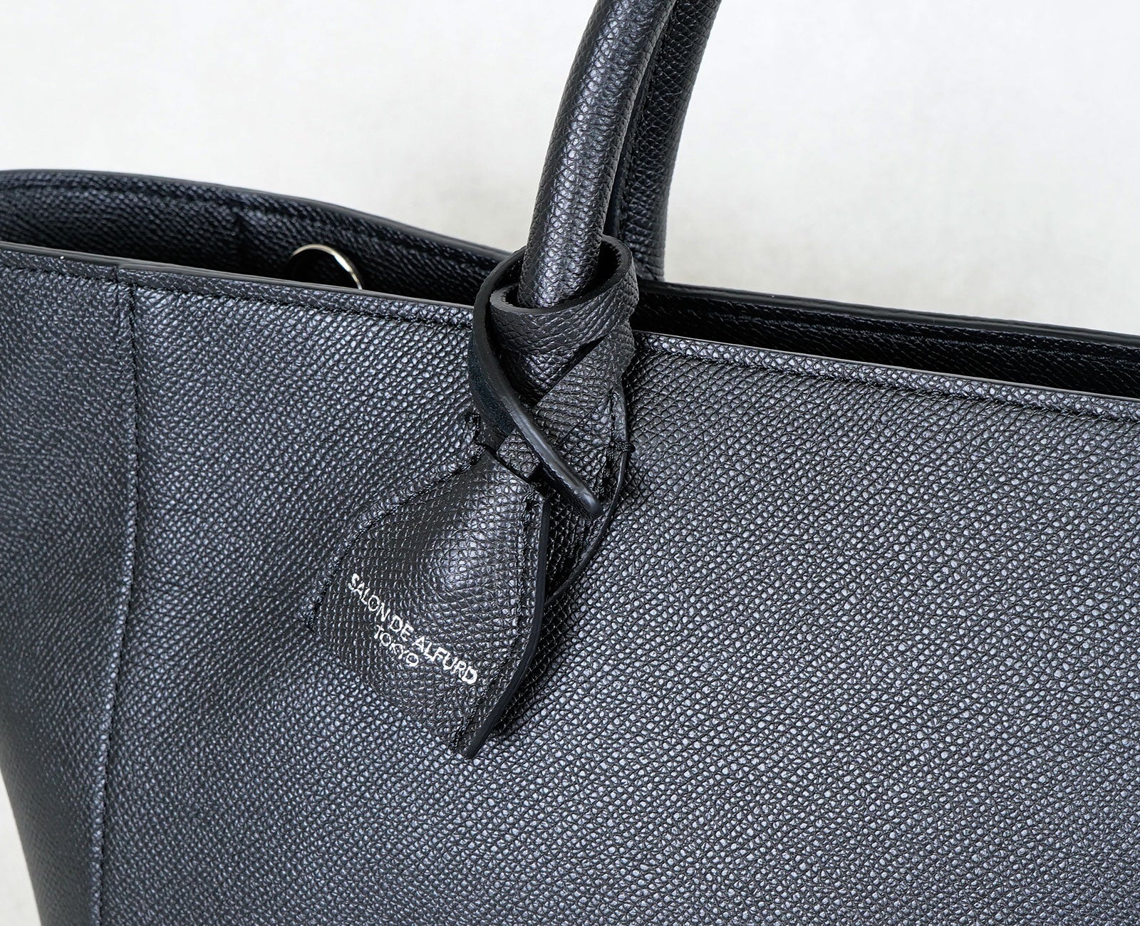 ブランドロゴが箔押しされた、上品に揺れるチャームがアクセント。