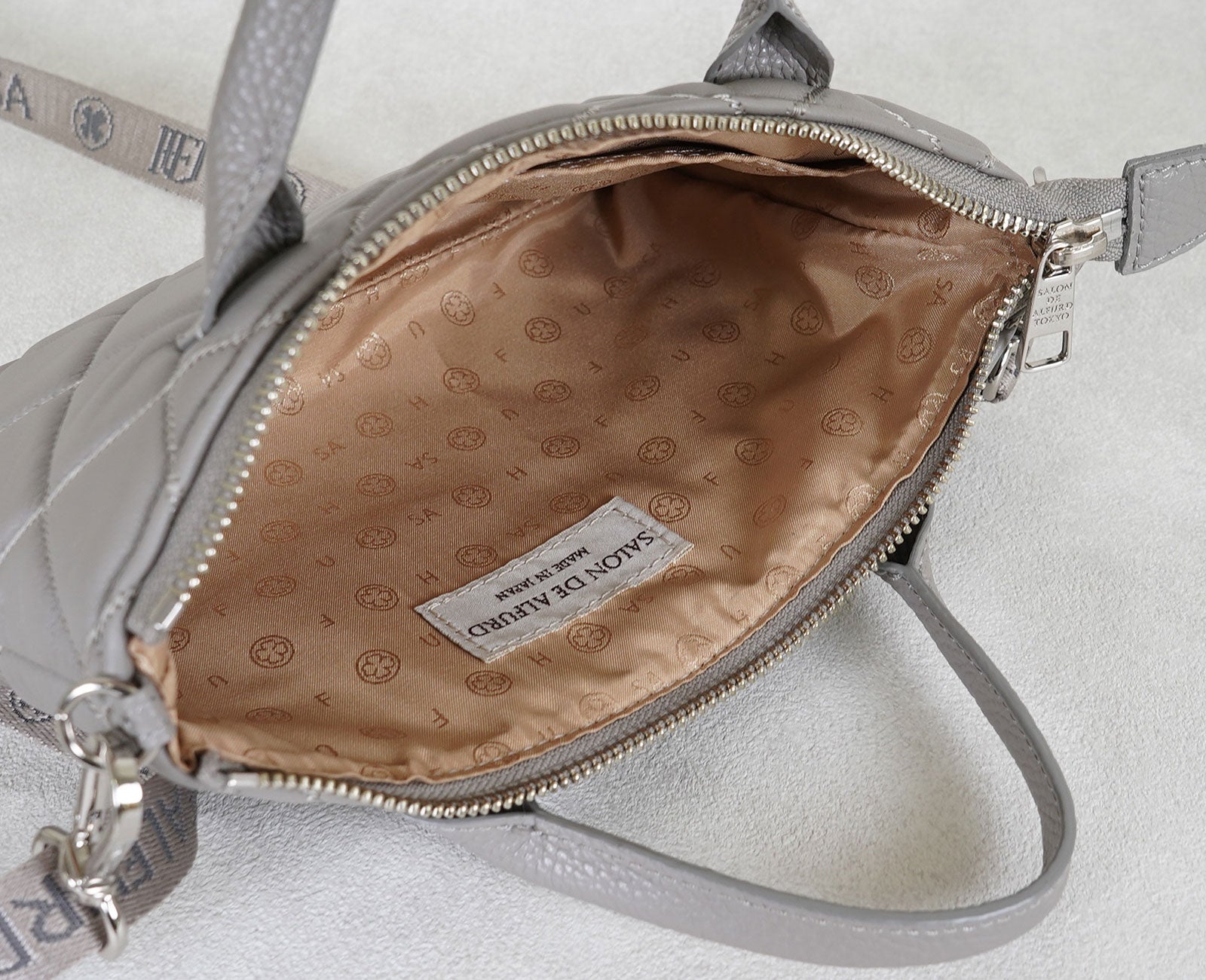 オリジナル裏地を採用。四つ葉のクローバーなどをあしらい、開けるたびにハッピーな気分になれるデザインにこだわりました