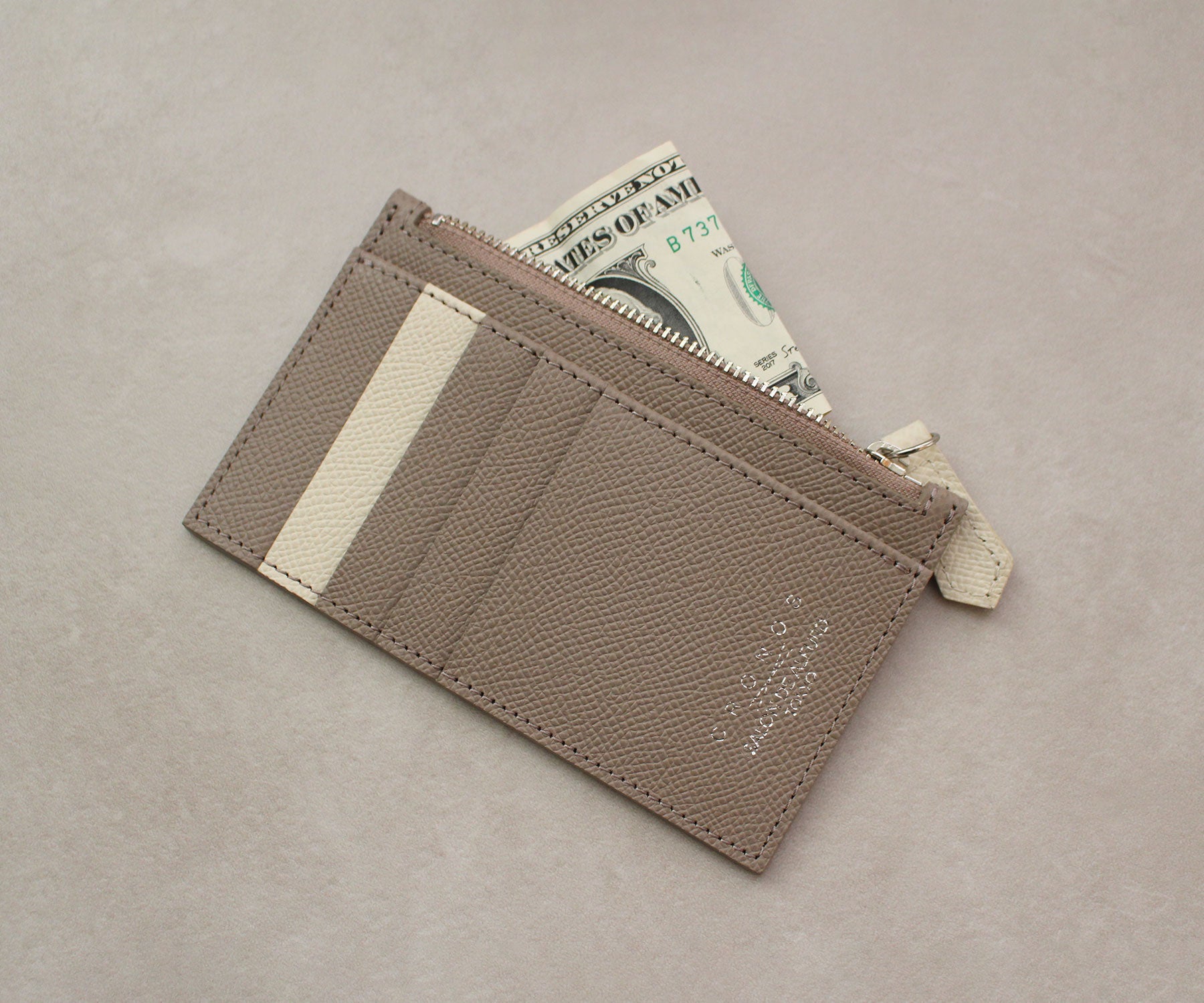 コインの他、三つ折りにしたお札も収納できるファスナー付きポケット。