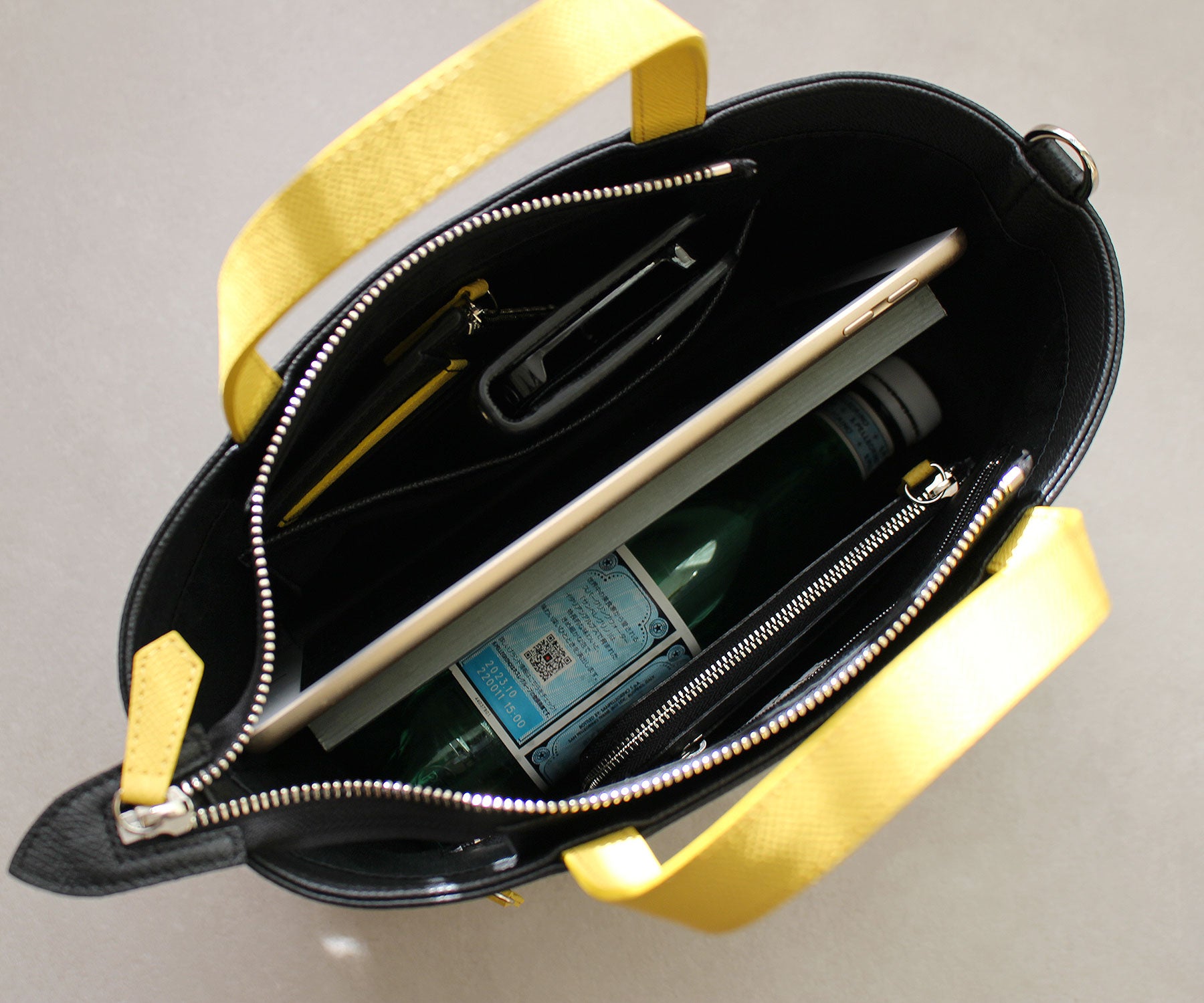 iPadやB5サイズのノート、500mlのペットボトルを横に収められる、日常使いに心地よいサイズ感。※B5サイズのノートを入れた場合、ファスナーは閉まりません。