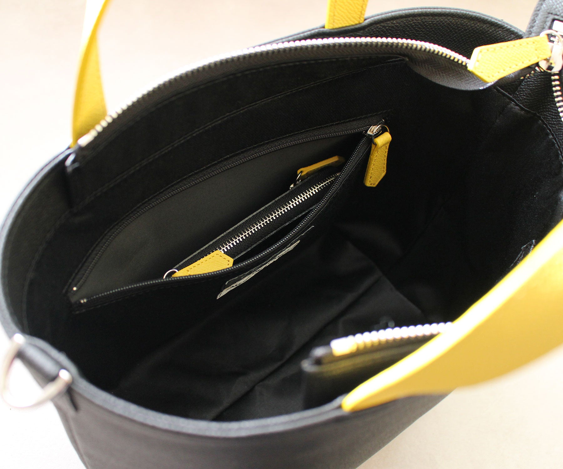 内側のファスナー付きポケットは、ミニ財布の収納にも対応した実用的なサイズ感。