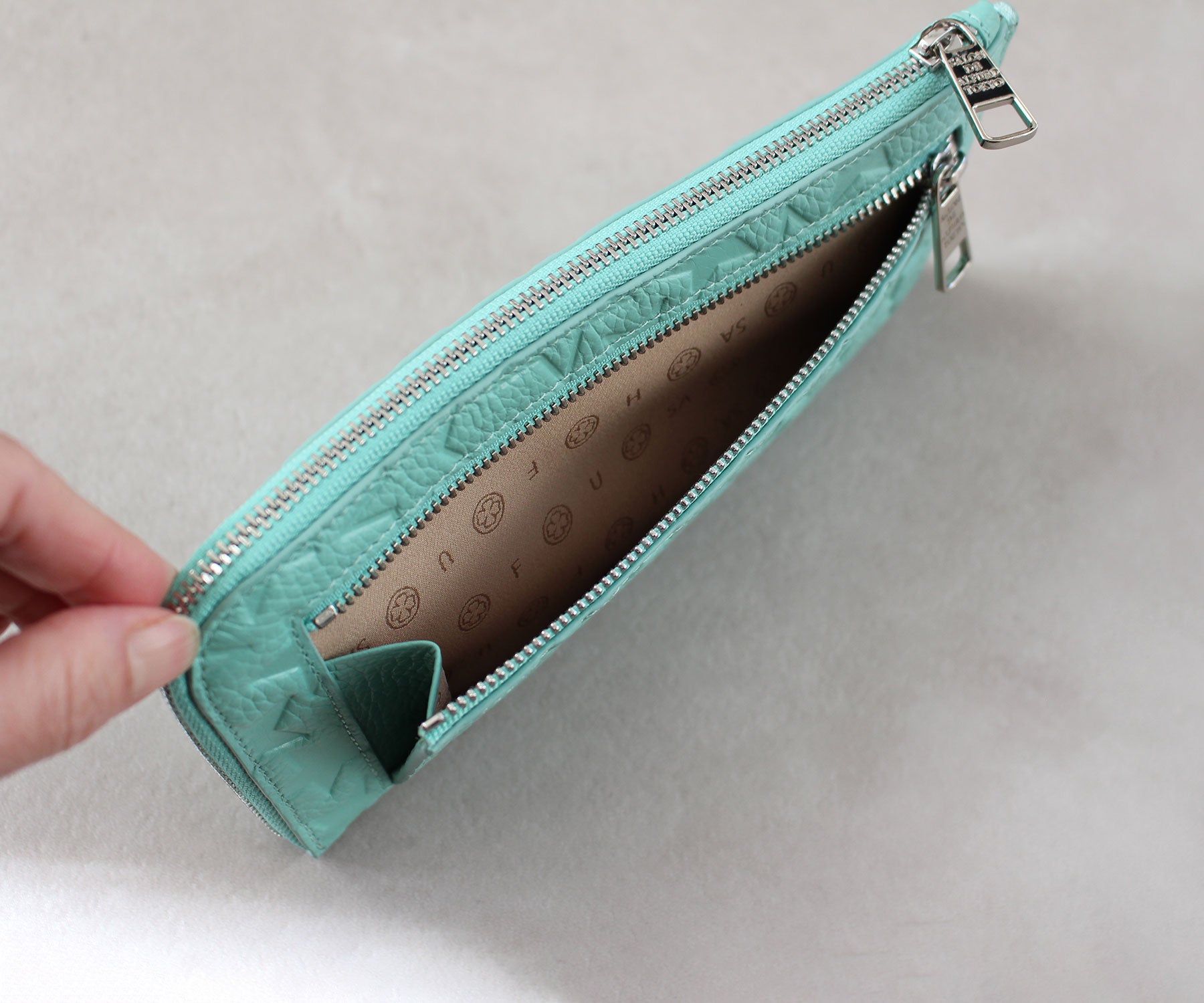 片側にマチを設けた、使い勝手のよい裏面ファスナーポケットを装備。中身が見やすく、出し入れもスムーズで、日常使いにさりげない快適さを添えます。