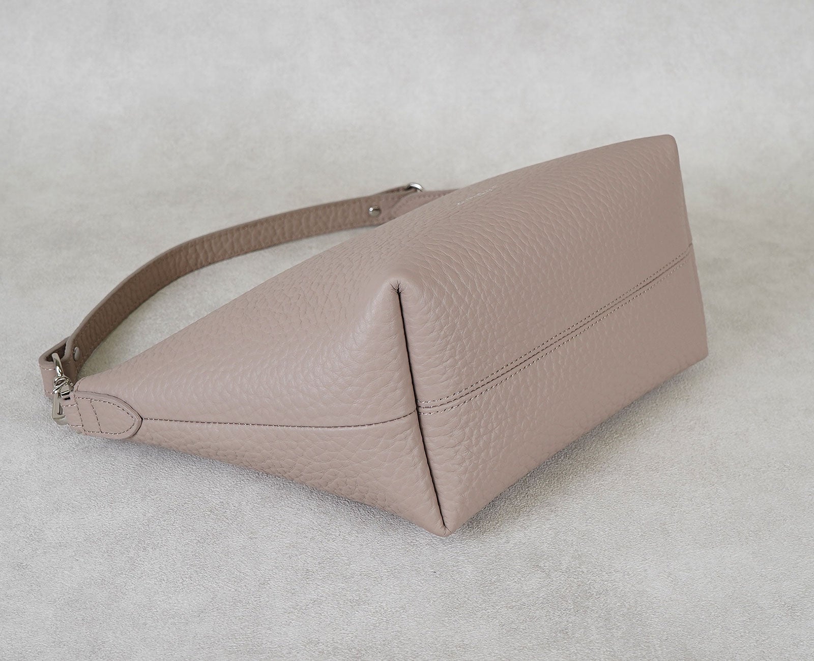 約12cmのマチと横長の台形フォルムで、荷物が入れやすく中身も見やすい設計。柔らかなレザーの質感も楽しめます