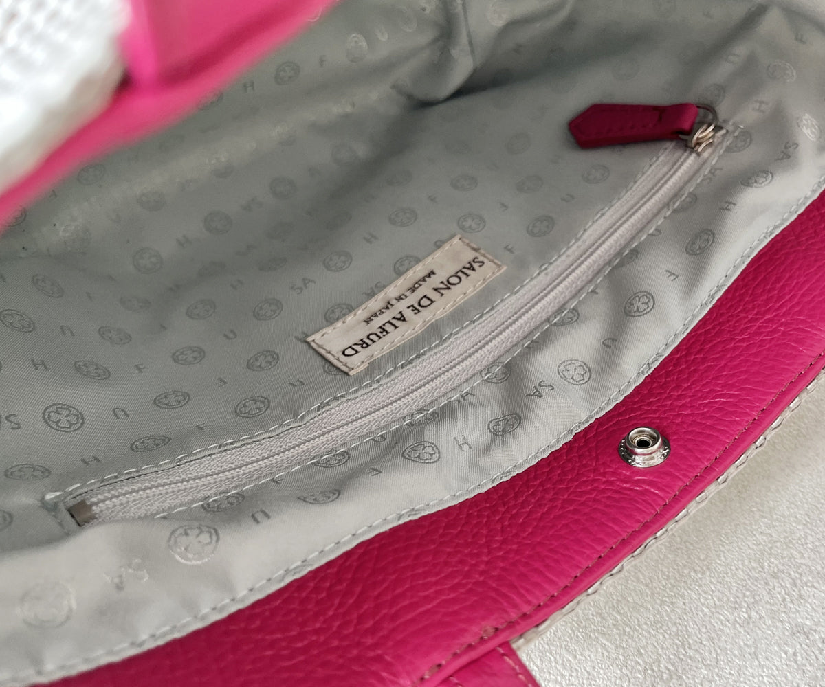 ミニ財布が収まるほどのファスナー付きポケットを備え、貴重品を美しく安心して持ち運べます。