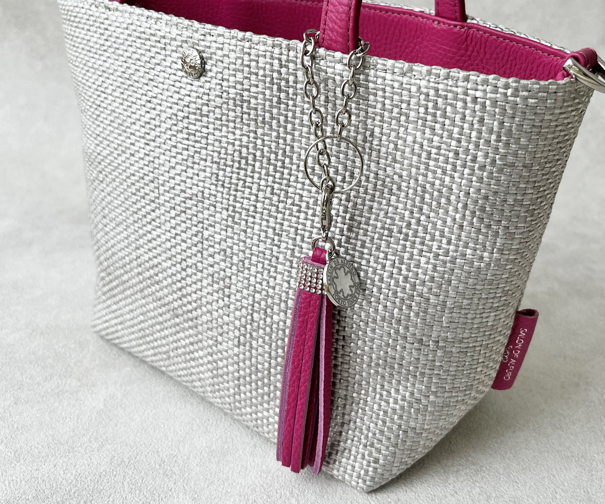 同素材・同カラーの小物を添えて、統一感のある装いへと印象を美しくアップデート。※バッグチャームは別売りです。