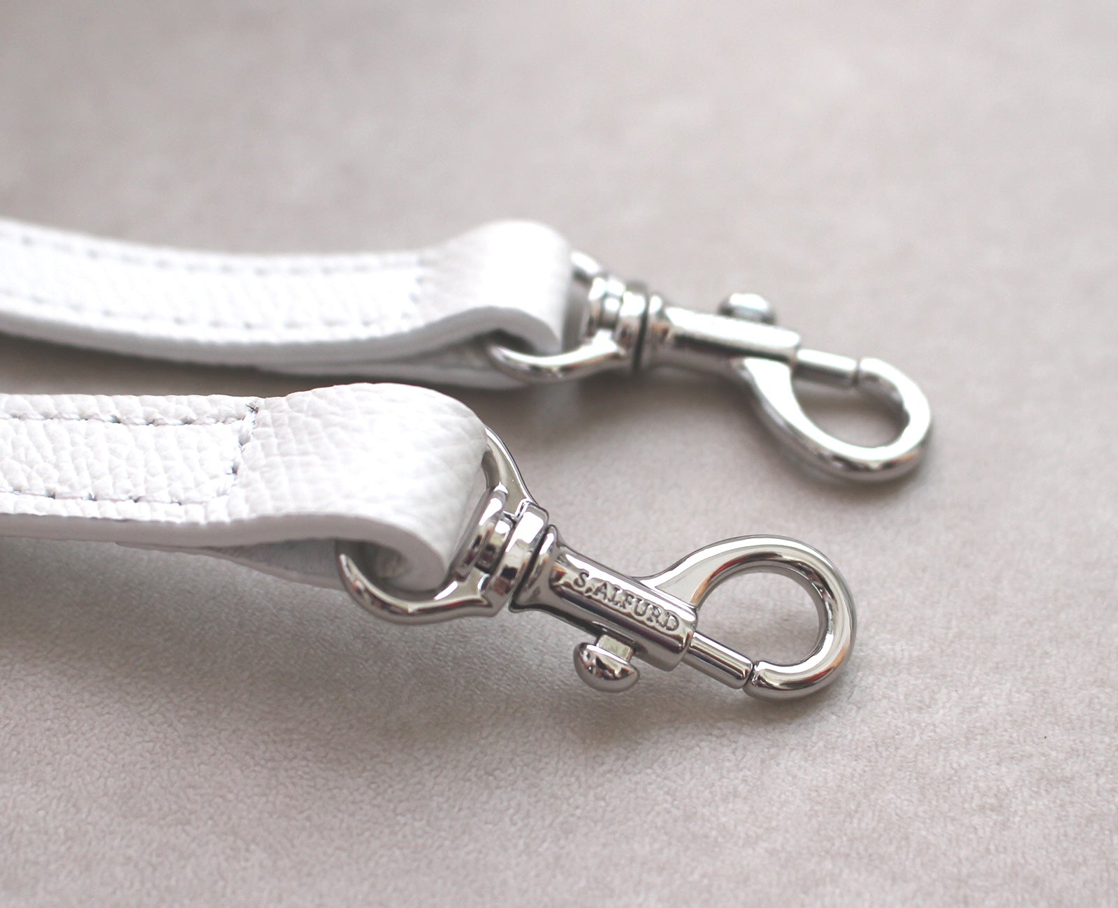 ロングショルダーストラップの小ぶりな金具にまでブランドロゴを刻印し、細部にまでこだわりを込めました。