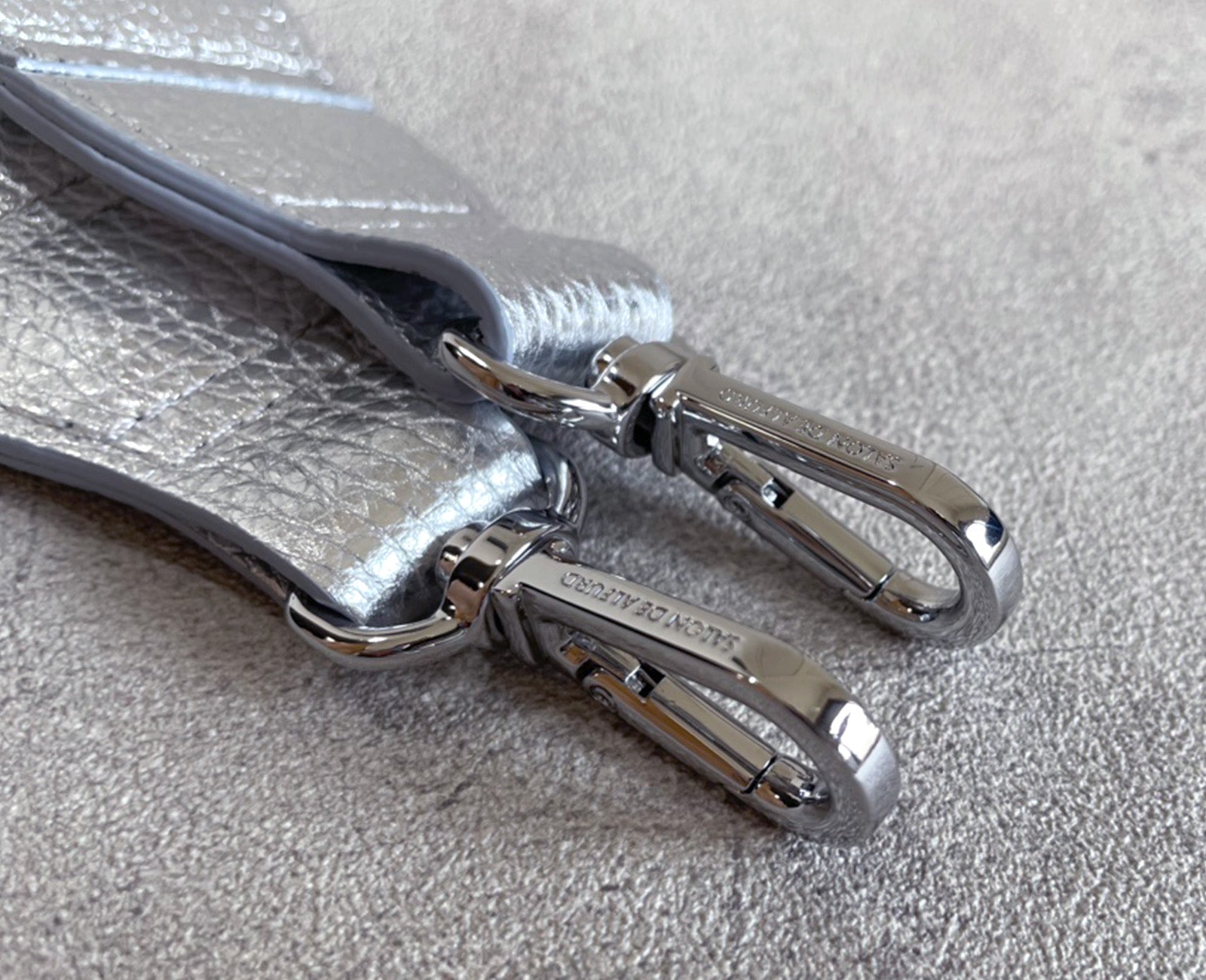 ブランド刻印が施された、シルバーに煌めく金具。